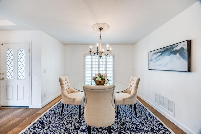 dining room featuring hardwood / wood-style floors and a chandelier