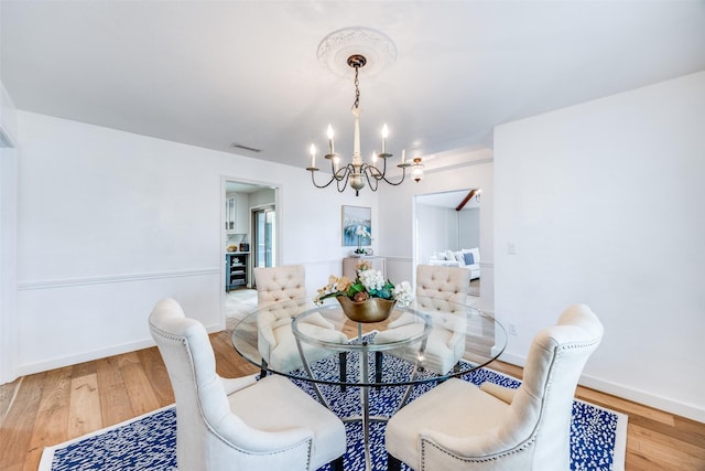 dining room featuring hardwood / wood-style floors and a notable chandelier