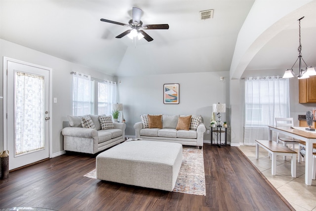 living room featuring vaulted ceiling, dark hardwood / wood-style floors, and ceiling fan with notable chandelier