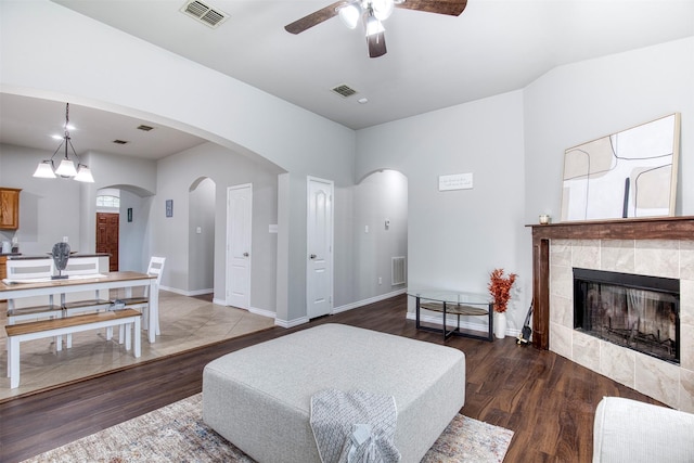 living room with hardwood / wood-style flooring, a tile fireplace, and ceiling fan