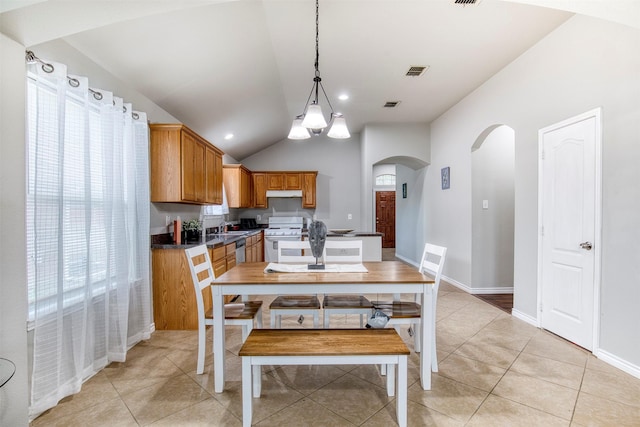 tiled dining area featuring a notable chandelier, lofted ceiling, and sink