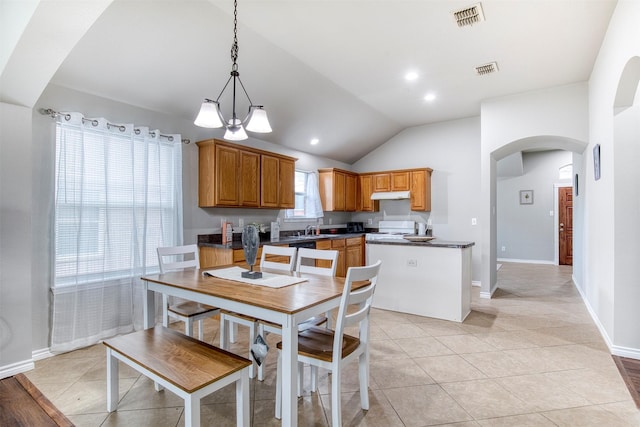 kitchen featuring pendant lighting, light tile patterned floors, lofted ceiling, and a chandelier