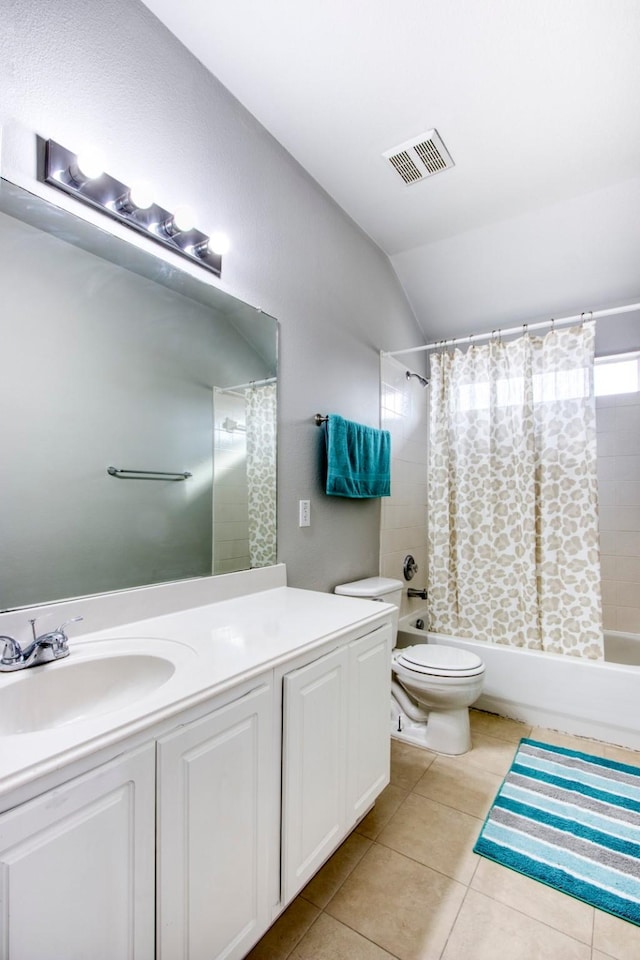 full bathroom with tile patterned floors, vanity, shower / tub combo with curtain, toilet, and vaulted ceiling