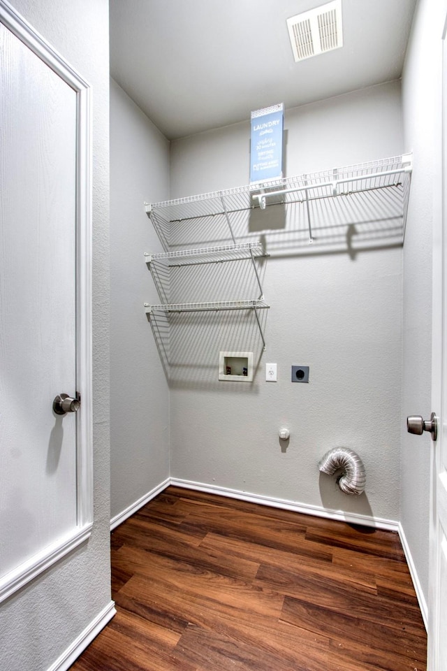 clothes washing area with hardwood / wood-style flooring, washer hookup, electric dryer hookup, and hookup for a gas dryer