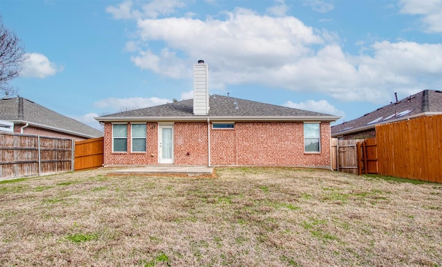 back of property with a lawn and a patio area