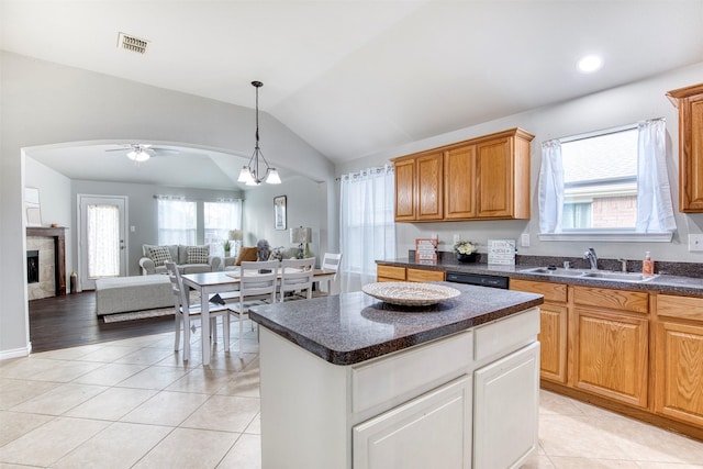 kitchen featuring ceiling fan with notable chandelier, lofted ceiling, a kitchen island, sink, and light tile patterned floors