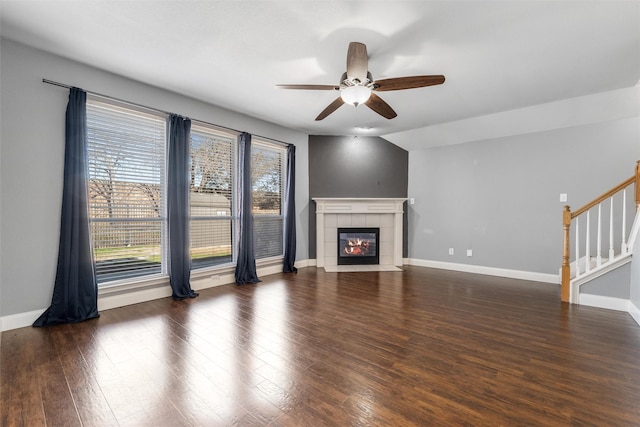 unfurnished living room featuring ceiling fan, a fireplace, lofted ceiling, and dark hardwood / wood-style floors