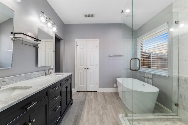 bathroom with vaulted ceiling, wood-type flooring, separate shower and tub, and vanity