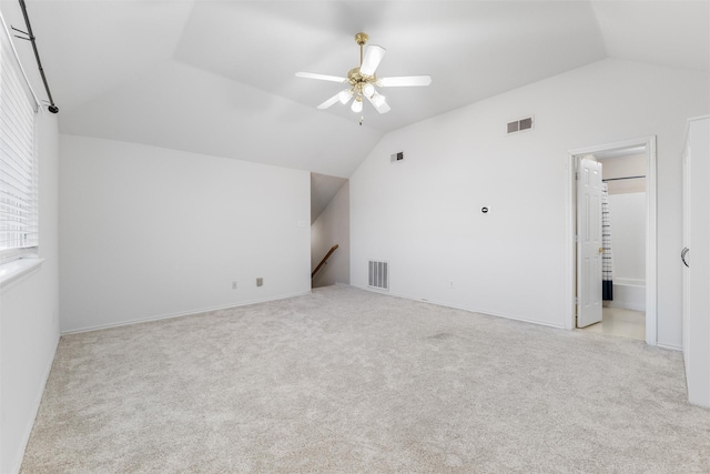 additional living space with lofted ceiling, light colored carpet, and ceiling fan