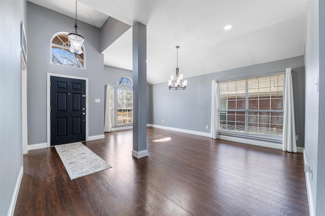 entrance foyer with high vaulted ceiling, dark hardwood / wood-style floors, and an inviting chandelier