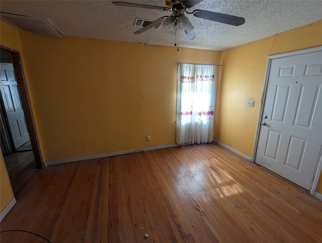 foyer entrance with hardwood / wood-style flooring, a textured ceiling, and ceiling fan