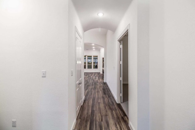 hall with vaulted ceiling and dark hardwood / wood-style flooring