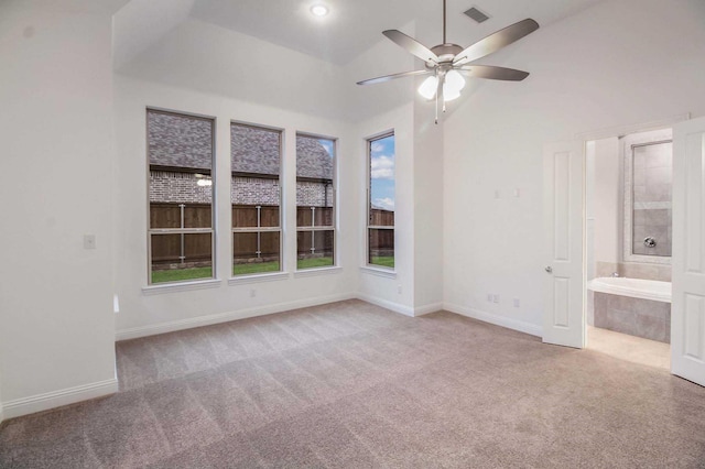 spare room featuring ceiling fan, light colored carpet, and lofted ceiling