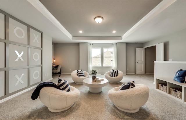 sitting room with a tray ceiling, ornamental molding, and carpet flooring