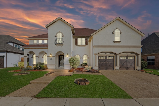 view of front of home featuring a lawn, a balcony, and a garage