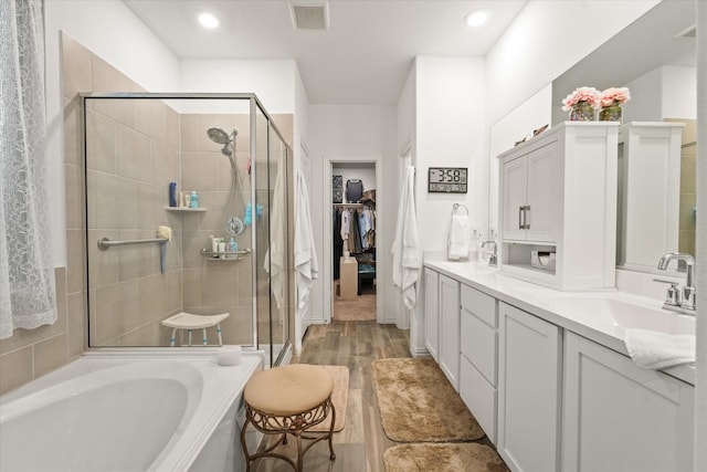 bathroom featuring wood-type flooring, vanity, and independent shower and bath