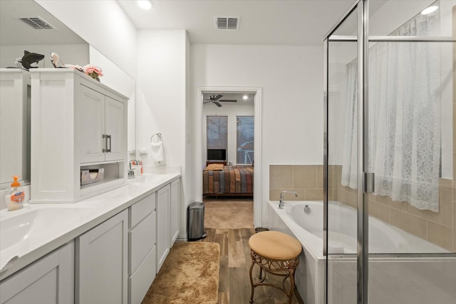 bathroom featuring ceiling fan, vanity, shower with separate bathtub, and hardwood / wood-style flooring