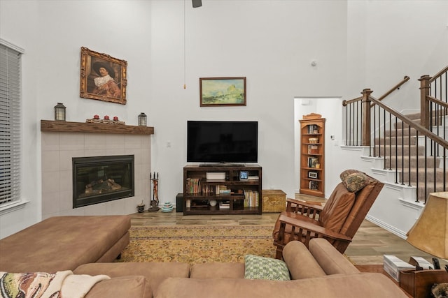 living room with a tiled fireplace and light hardwood / wood-style floors