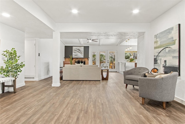 living room with ceiling fan, light hardwood / wood-style flooring, and french doors