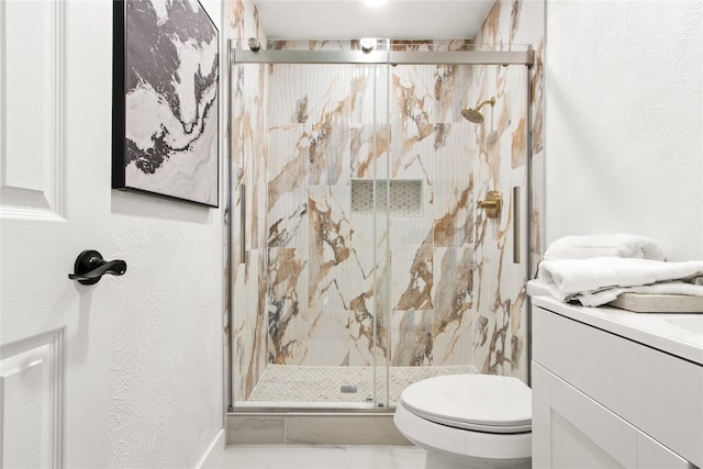 bathroom featuring a shower with shower door, vanity, and toilet