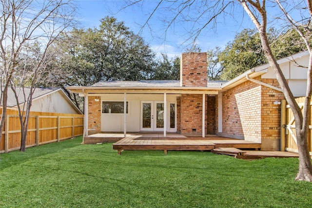 rear view of property with a lawn, french doors, and a deck