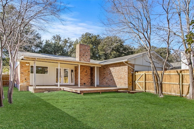 back of property with a wooden deck and a yard