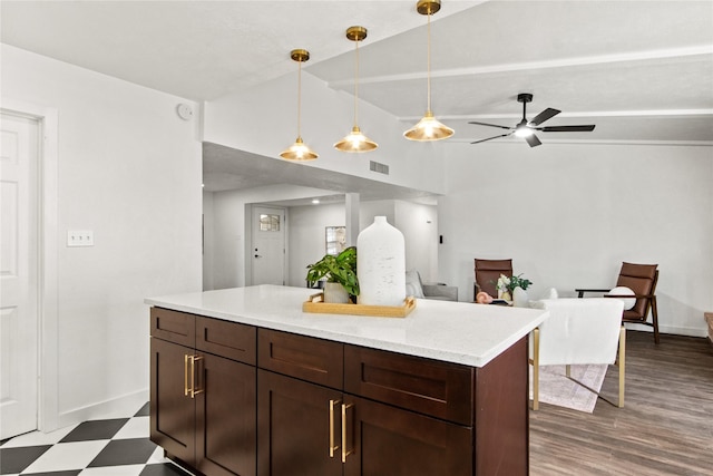 kitchen with lofted ceiling, ceiling fan, dark brown cabinetry, hanging light fixtures, and light stone counters