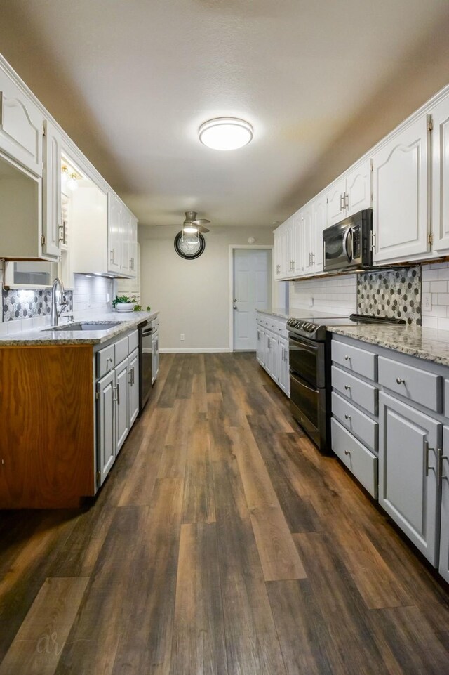 kitchen featuring light stone counters, dark wood-type flooring, white cabinetry, and appliances with stainless steel finishes