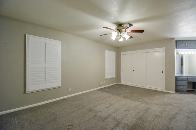 unfurnished bedroom featuring ceiling fan, a closet, and carpet floors