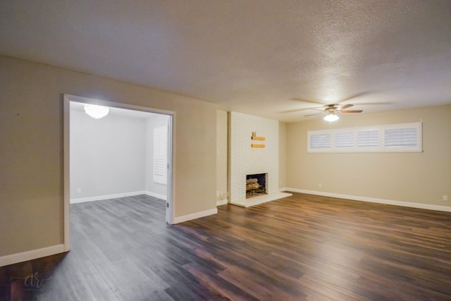 unfurnished living room with ceiling fan, dark wood-type flooring, a fireplace, and a textured ceiling