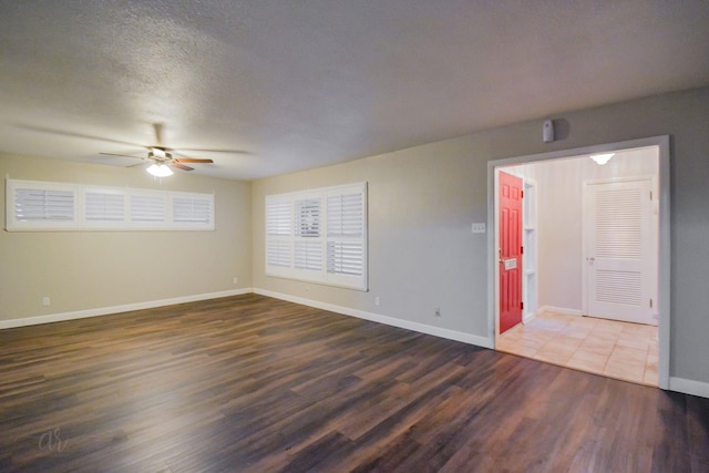 empty room featuring ceiling fan, a textured ceiling, and dark hardwood / wood-style floors