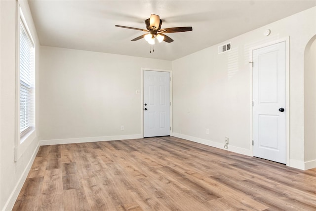 unfurnished room featuring light wood-type flooring, ceiling fan, and plenty of natural light