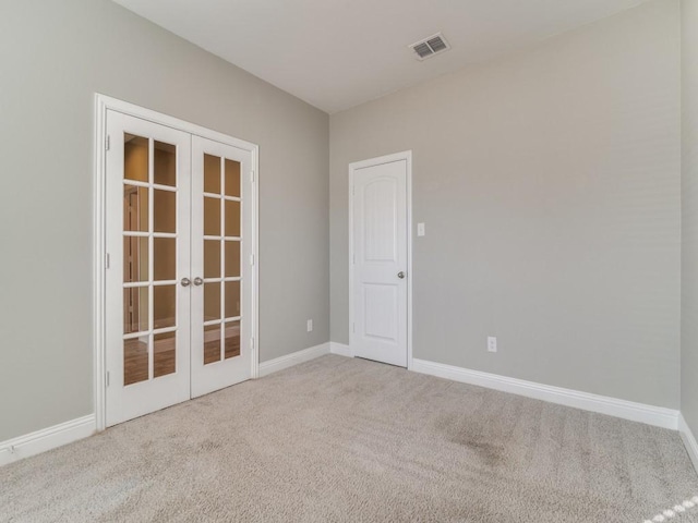 unfurnished room with carpet floors and french doors