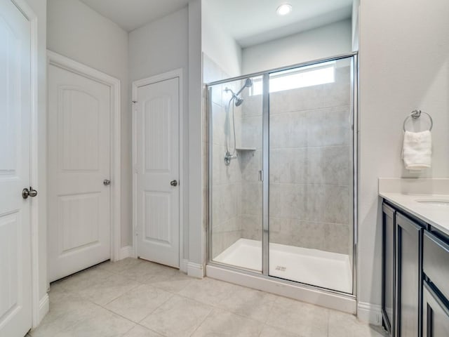 bathroom featuring walk in shower, vanity, and tile patterned flooring