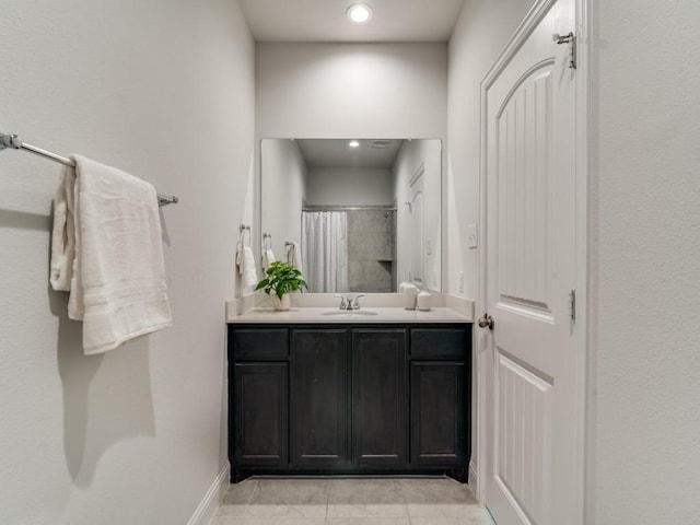 bathroom with tile patterned flooring, walk in shower, and vanity