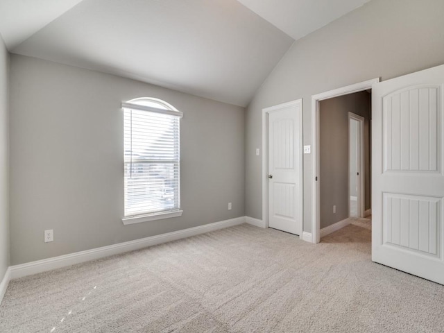 unfurnished bedroom with light carpet and vaulted ceiling