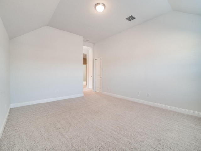 empty room with carpet floors and vaulted ceiling