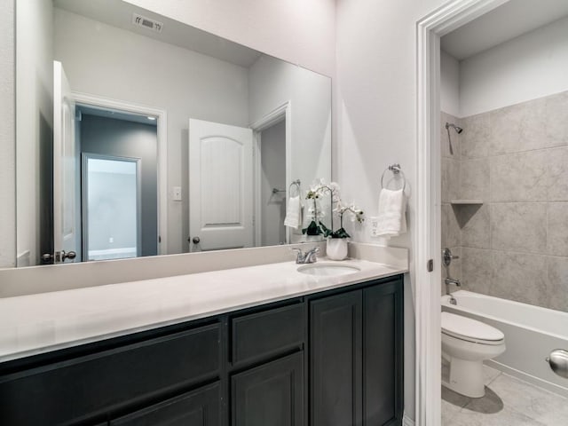 full bathroom featuring toilet, tiled shower / bath, tile patterned floors, and vanity