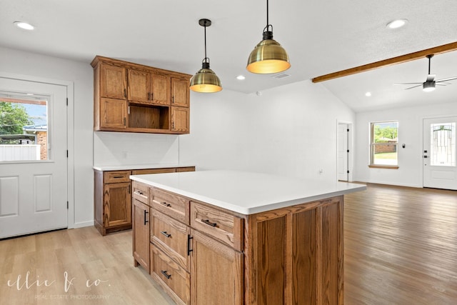 kitchen featuring a kitchen island, decorative light fixtures, lofted ceiling with beams, ceiling fan, and light hardwood / wood-style flooring