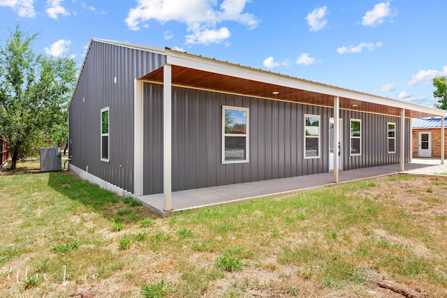 back of house featuring central air condition unit, a patio area, and a yard