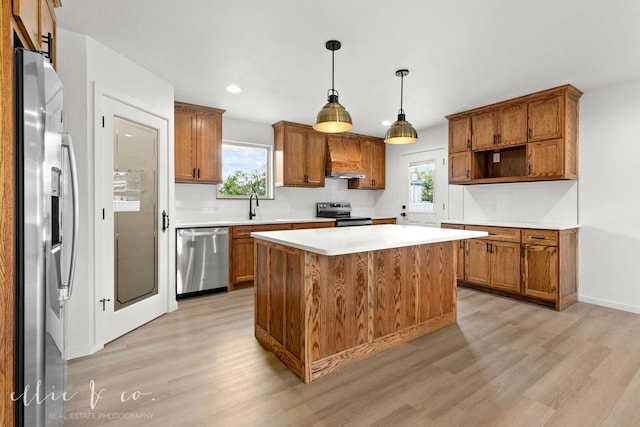 kitchen featuring decorative light fixtures, plenty of natural light, appliances with stainless steel finishes, and a center island