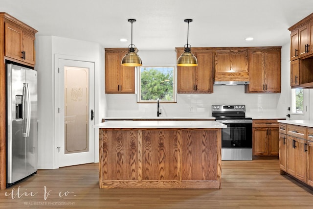 kitchen with pendant lighting, dark hardwood / wood-style floors, a center island, and stainless steel appliances