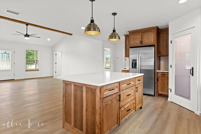 kitchen with light hardwood / wood-style floors, stainless steel refrigerator with ice dispenser, decorative light fixtures, vaulted ceiling with beams, and a center island