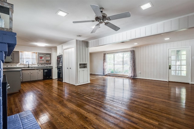 unfurnished living room with ceiling fan, sink, dark hardwood / wood-style flooring, and plenty of natural light