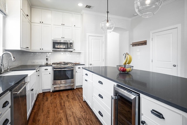 kitchen with tasteful backsplash, white cabinetry, stainless steel appliances, and wine cooler