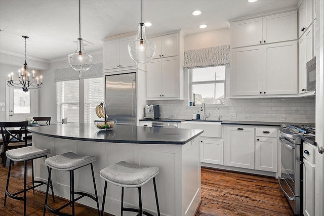 kitchen featuring white cabinetry, a center island, and built in appliances