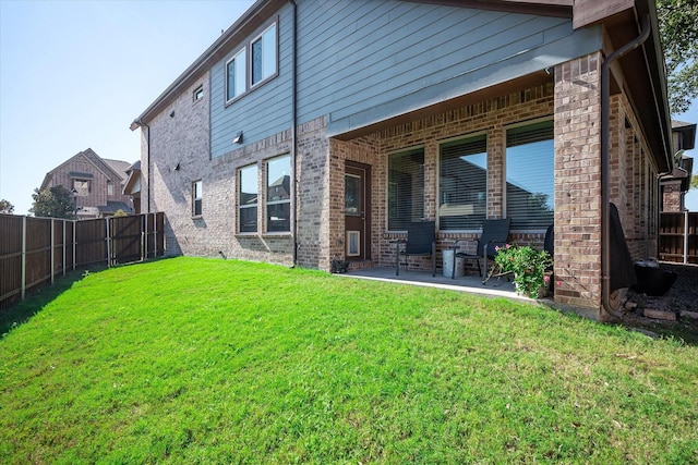 rear view of house with a yard and a patio