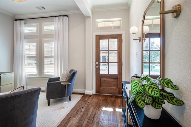 foyer with dark wood-type flooring, crown molding, and a chandelier