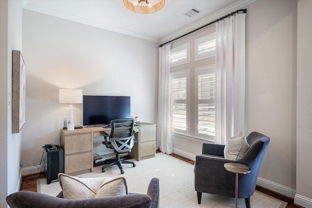 office space with ornamental molding, a healthy amount of sunlight, and light hardwood / wood-style flooring