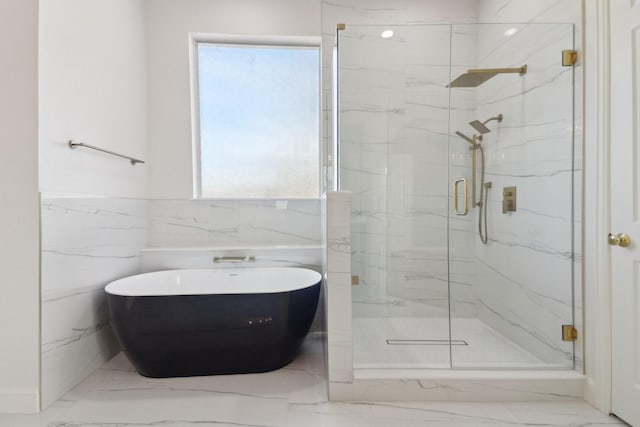 bathroom with tile walls, plenty of natural light, and separate shower and tub